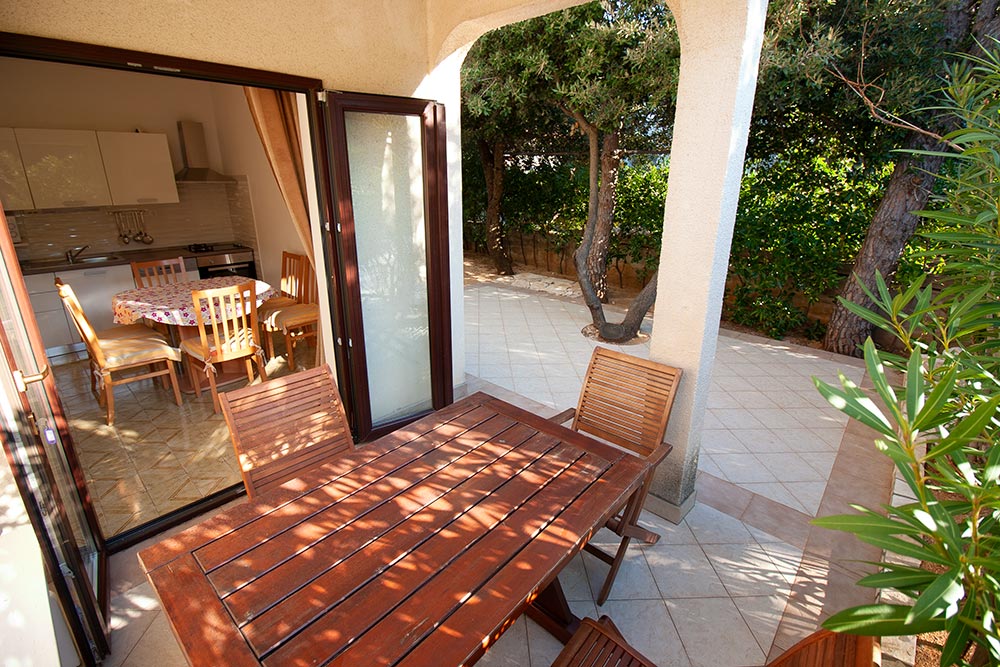 Terrace of Apartment S1-B with outdoor table, chairs and natural shade